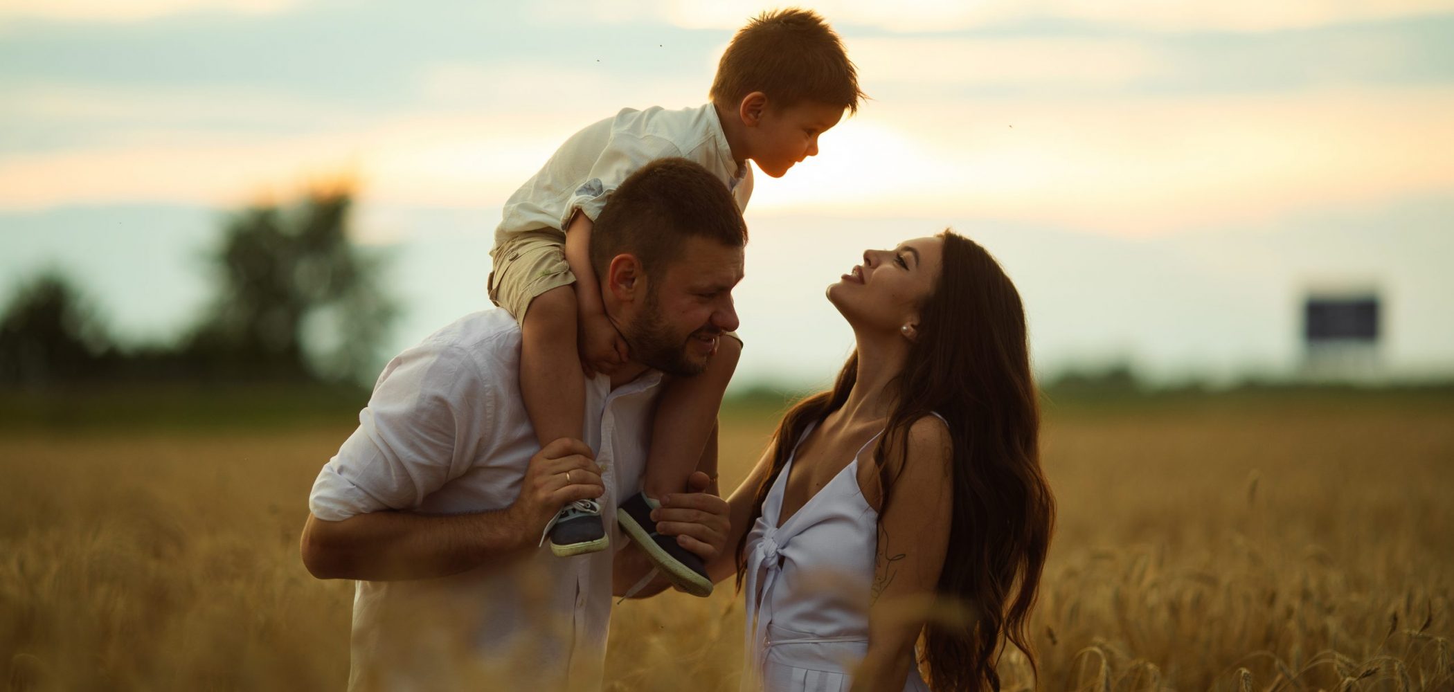 Picture of cheerful caucasian mum, dad and their child have fun together and smiles on the field